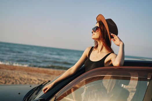 pretty woman in sunglasses near the car on the beach travel lifestyle. High quality photo