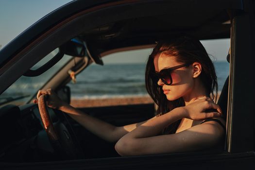 woman on the beach is with a car wearing sunglasses travel. High quality photo