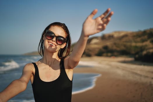 cheerful woman in a black swimsuit walking along the beach tropics summer. High quality photo