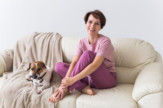 Young attractive woman dressed in beautiful colorful pajama posing as a model in her living room. Comfortable sleepwear, home relaxation and female fashion concept