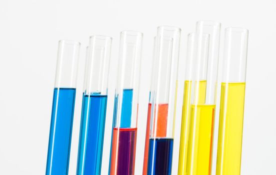 Science laboratory research and development. Close up test tubes with colorful substance on white background. Chemical manufacture concept with glass equipment. Modern biotechnology industry.