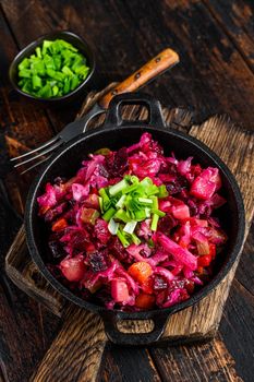 Russian beetroot vegetable salad vinaigrette in a pan. Wooden background. Top view.