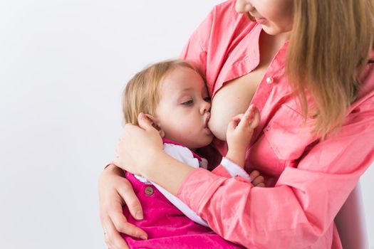 Mother breastfeeding baby in her arms at home. Young woman nursing and feeding baby. Concept of lactation infant.