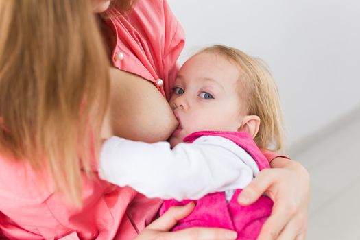 Mother breast feeding and hugging her baby.