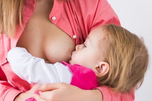 Mother breastfeeding baby in her arms at home. Young woman nursing and feeding baby. Concept of lactation infant.