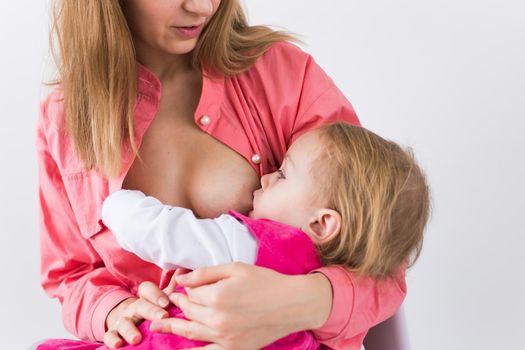 Mother breastfeeding baby in her arms at home. Young woman nursing and feeding baby. Concept of lactation infant.