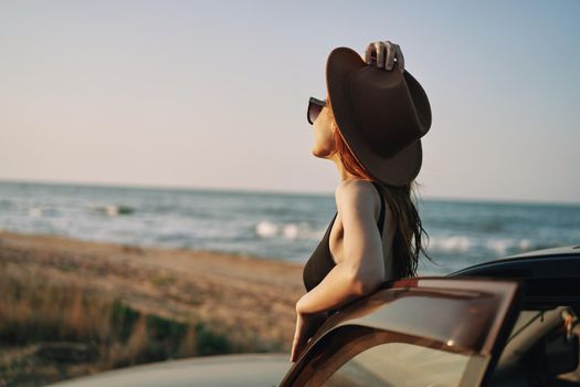 pretty woman in sunglasses near the car on the beach travel lifestyle. High quality photo