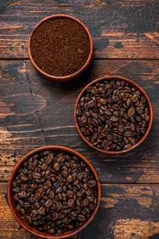 Background of coffee beans and grinded ground coffee. Dark wooden background. Top view.