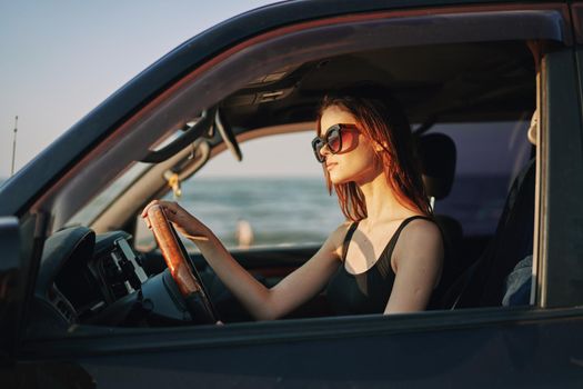 cheerful woman in sunglasses driving a car trip travel. High quality photo