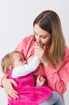 Mother breastfeeding baby in her arms at home. Young woman nursing and feeding baby. Concept of lactation infant.