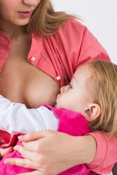 Mother breastfeeding baby in her arms at home. Young woman nursing and feeding baby. Concept of lactation infant.