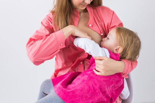 Mother breastfeeding baby in her arms at home. Young woman nursing and feeding baby. Concept of lactation infant.