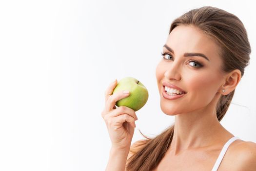 Beautiful woman with perfect skin holding green apple isolated on white background