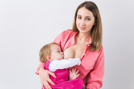 Young beautiful mother, breastfeeding her baby girl. Mom breastfeeding infant.