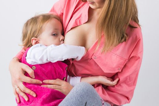 Mother breastfeeding baby in her arms at home. Young woman nursing and feeding baby. Concept of lactation infant.