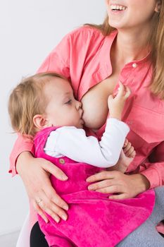 Mother breastfeeding baby in her arms at home. Young woman nursing and feeding baby. Concept of lactation infant.