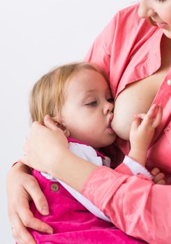 Mother breastfeeding baby in her arms at home. Young woman nursing and feeding baby. Concept of lactation infant.