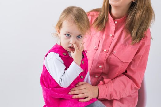 little girl pick in finger in the nose.