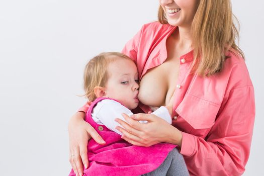 Mother breastfeeding baby in her arms at home. Young woman nursing and feeding baby. Concept of lactation infant.