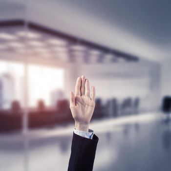 Close of businesswoman hand touching screen with palm and office at background