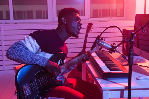 Create music and a recording studio concept - Bearded man guitarist recording electric guitar track in home studio.