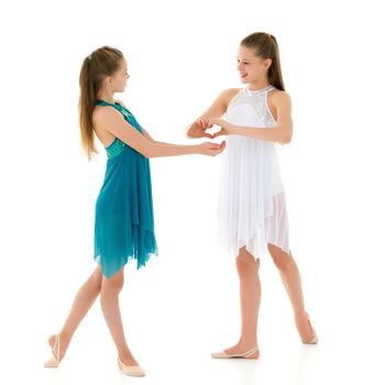 Two adorable girls gymnasts folded hands in the form of a heart. Sign of love. Isolated on a white background.