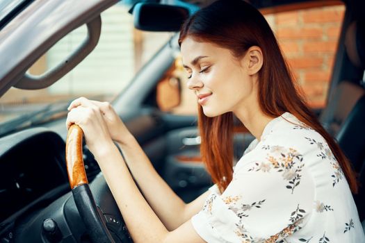 cute red-haired woman driving a car lifestyle trip. High quality photo
