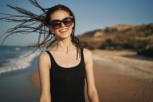 woman walks along the sandy shore in a black swimsuit sun tropics. High quality photo