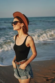 woman walking on the beach hat travel vacation sun. High quality photo
