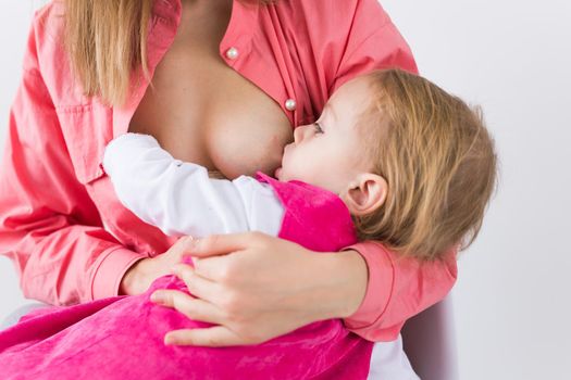 Young beautiful mother, breastfeeding her baby girl. Mom breastfeeding infant.