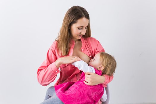 Young beautiful mother, breastfeeding her baby girl. Mom breastfeeding infant.