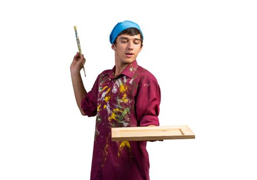 Young handsome painter artist holding paintbrush and canvas in frame. Portrait of happy painter isolated on white background. Creative hobby and artistic occupation. Art school student posing.