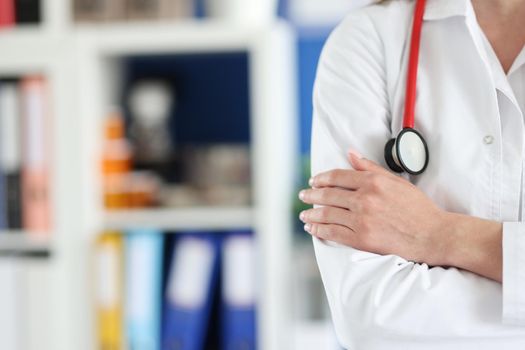 Woman doctor in uniform folded her arms over her chest close-up, blurry. Preparedness of medical personnel for a pandemic