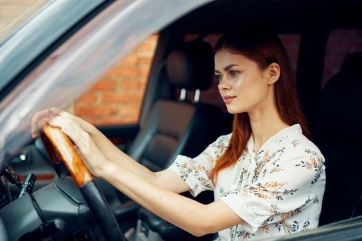 cute red-haired woman driving a car lifestyle trip. High quality photo