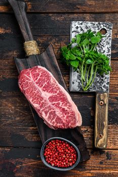 Raw Top Blade beef meat steak. Dark wooden background. Top view.