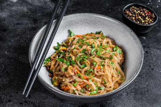 Wok Hot Asian cellophane noodles with chicken meat. Black background. Top view.