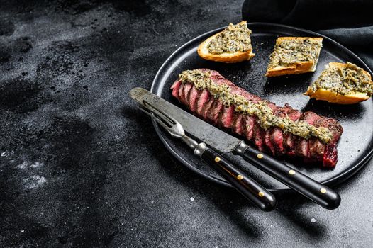 Grilled skirt or machete marble beef steak. Black background. Top view. Copy space.