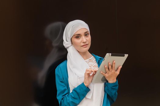 Smiling Asian girl student professional employee holding tablet and sit at outdoor park, happy woman studying e learning online software using technology app for work education.