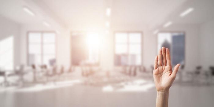 Close of woman hand touching screen with palm and office at background