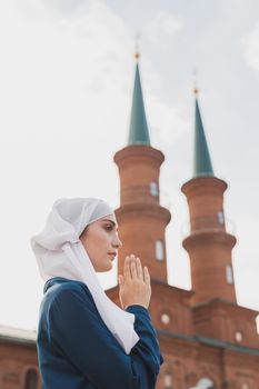 Young Muslim woman prayer wear hijab fasting pray to allah on mosque background
