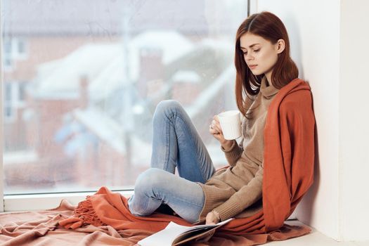 woman looking out the window on the windowsill Comfort weekend rest. High quality photo