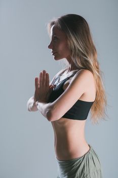 Fitness girl with sporty body posing at studio on grey background. Fitness smiling model in sportswear. Weight Loss. Healthy lifestyle. Sporty healthy female