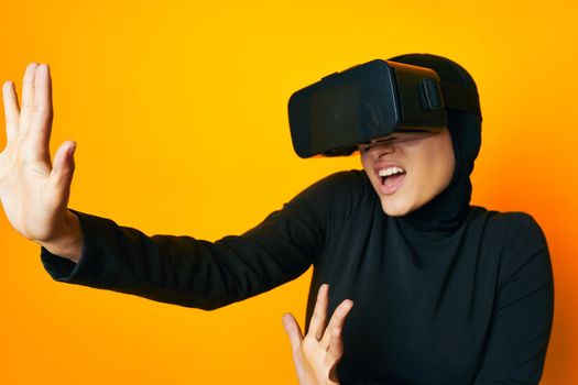 cheerful woman in black hijab VR glasses emotions studio lifestyle. High quality photo