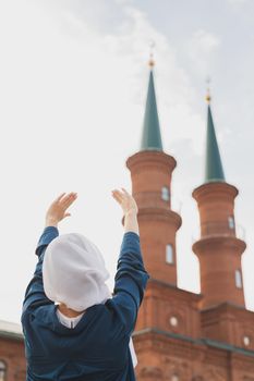 Young Muslim woman prayer wear hijab fasting pray to allah on mosque background