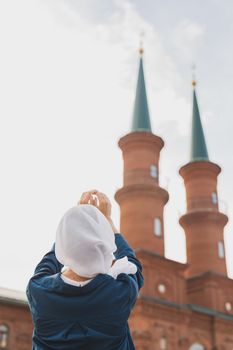 Young Muslim woman prayer wear hijab fasting pray to allah on mosque background