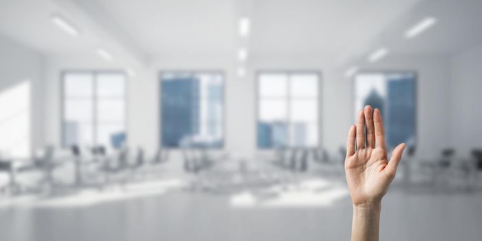 Close of woman hand touching screen with palm and office at background