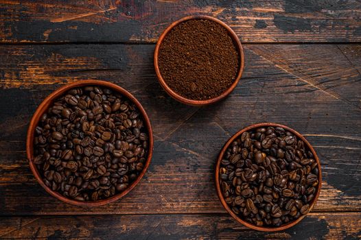 Background of coffee beans and grinded ground coffee. Dark wooden background. Top view.