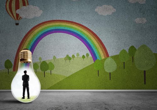 Businessman inside light bulb in room against nature drawn concept