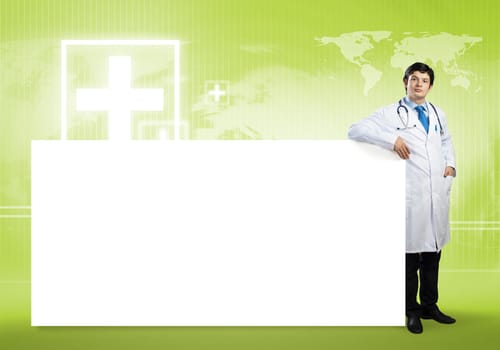 Young handsome doctor with white blank banner. Place your text