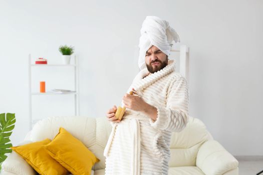 Funny handsome man pretends to play on massage brush as a guitar. Fun, spa and humor concept